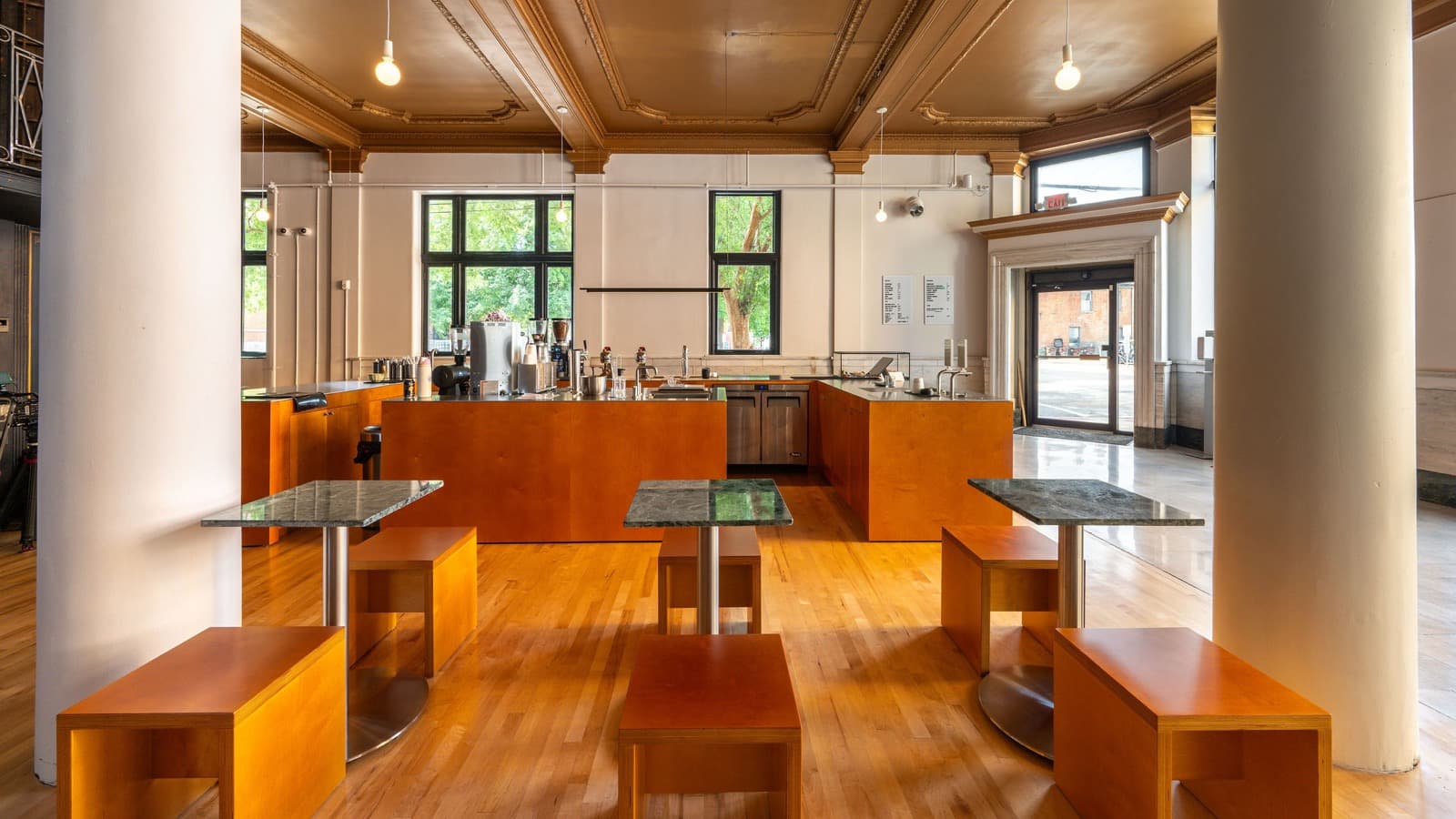 Interior of Locke Coffee looking across the seating area toward the Modbar espresso bar, with the front entry door and menu board visible, at 400 York St in Newport, KY, a specialty coffee shop near Cincinnati